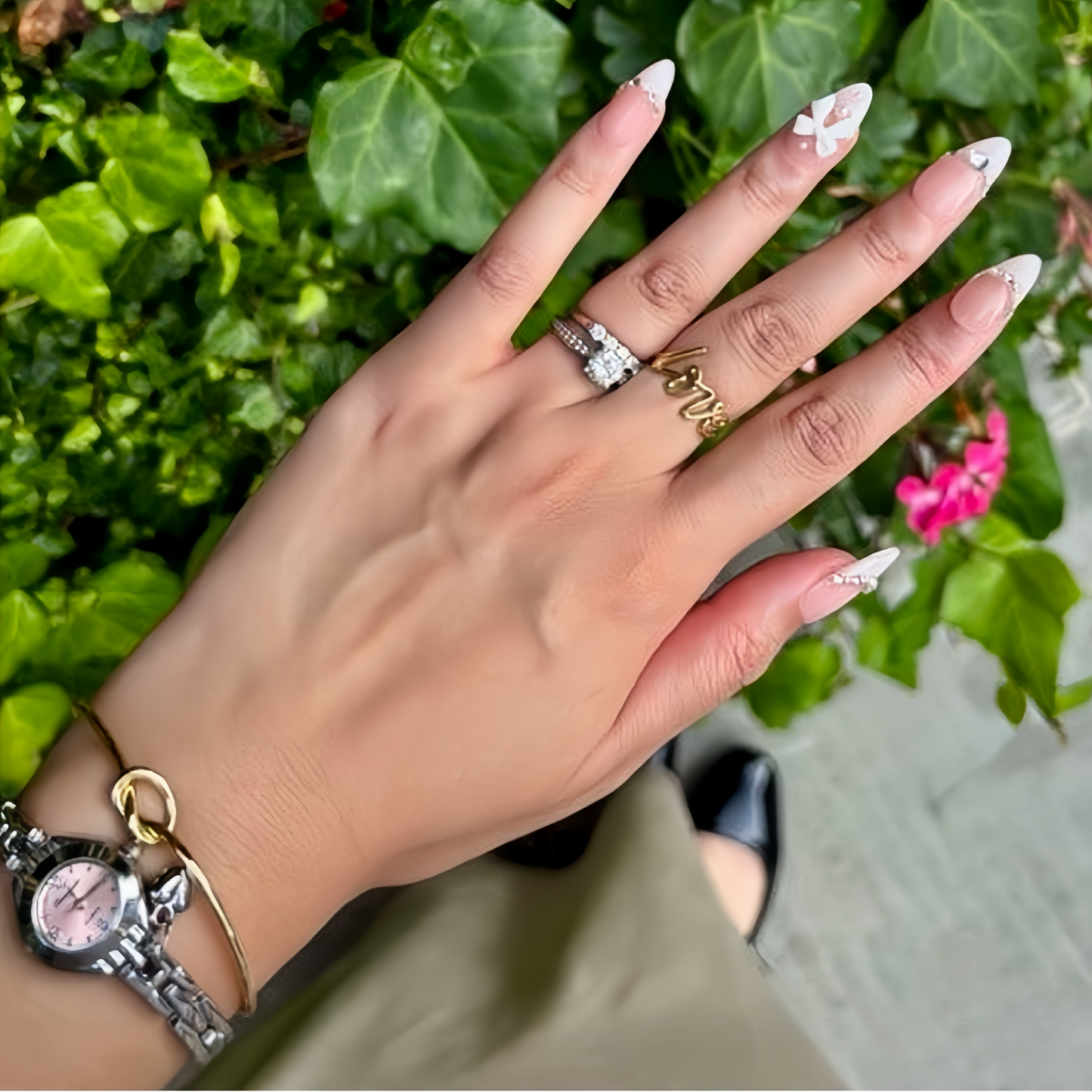 Pinkie Promise Nails Press-Ons Reusable Best Press-on Nails Salon Quality Nails at home Aalyah Medium Almond Hand Press-On Nails, Hand with decorative nails and rings against a green leafy
