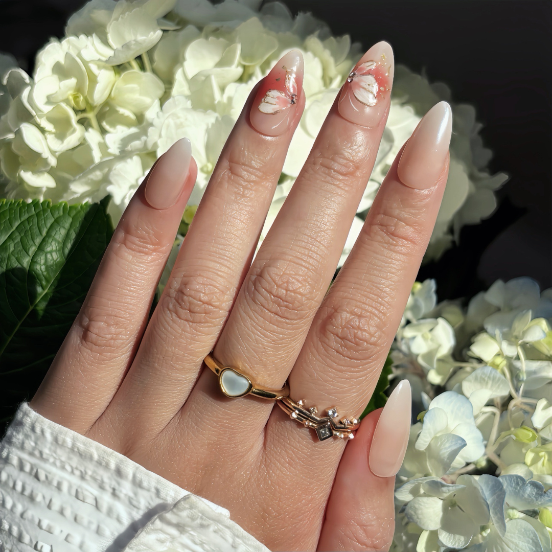 Pinkie Promise Nails Press-Ons Reusable Best Press-on Nails Salon Quality Nails at home Faye Medium Almond Hand Image Build Your Kit Press-On Nails, Hand with a gold ring against a background of white flowers