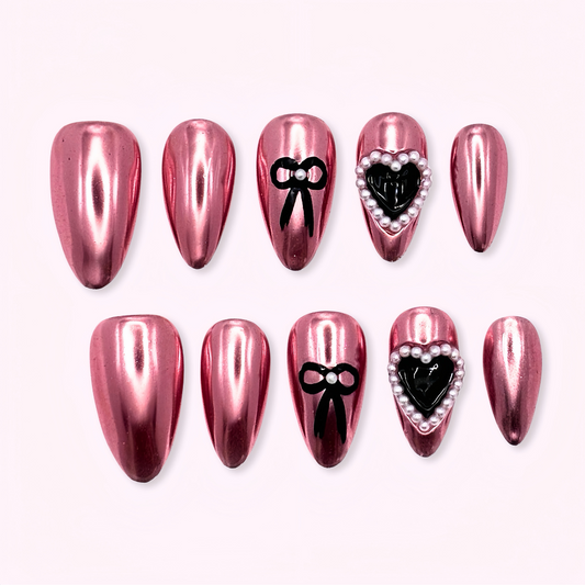 Set of pink nail art designs with black bows and hearts on a white background